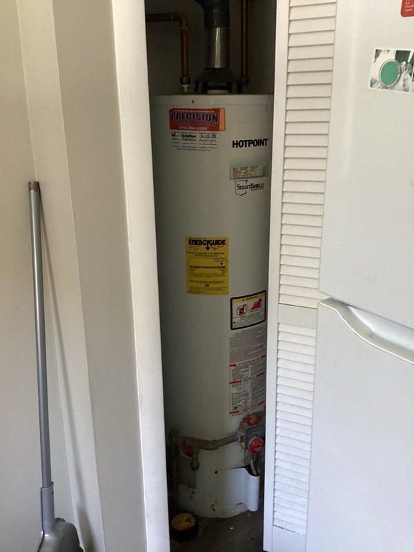 Completed rental inspection for upper unit apartment 2, evaluating a 10-year-old Comfortmaker water heating system. Inspected Hotpoint water heater installation, verified proper plumbing connections including inlet/outlet copper piping and shutoff valves, and documented unit condition with manufacturer labels and specifications visible. Examined associated ductwork with insulated covering and confirmed proper mounting and connections. All components photographed and assessed for rental property compliance.