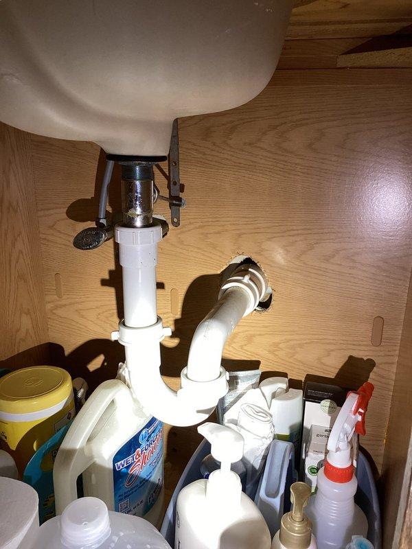 Conducted comprehensive plumbing assessment for bathroom remodel project, documenting existing fiberglass shower stall installation with integrated shelving system and center drain configuration. Evaluated under-sink plumbing infrastructure including P-trap assembly, PVC drain lines, and supply connections to determine scope of work required for renovation project.