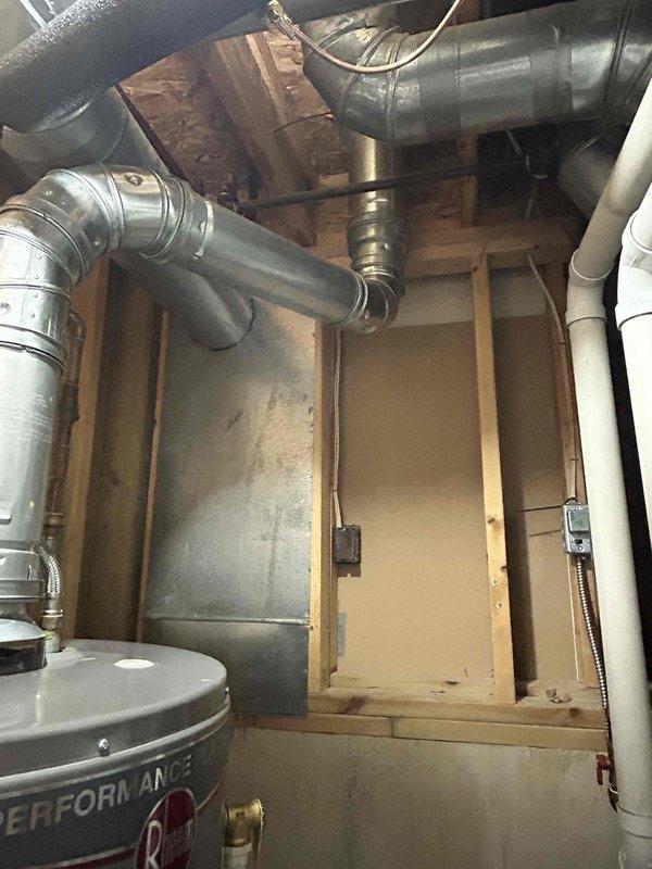 Conducted site assessment for new gas line installation to supply gas stove in upstairs kitchen of 30-year-old residential property. Evaluated existing basement mechanical room containing HVAC system, water heater, and current plumbing infrastructure to determine optimal routing path. Documented exposed floor joists, existing ductwork configuration, and PVC plumbing runs to plan gas line pathway from basement to kitchen level while maintaining proper clearances from electrical, plumbing, and HVAC components.