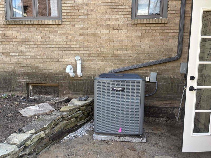 Returned to property to complete reinstallation of outdoor air conditioning condenser unit on existing concrete pad against exterior brick wall. Successfully repositioned and secured unit, reconnected refrigerant lines and electrical connections, verified proper drainage through condensate line, and performed system startup and operational testing to ensure proper function.