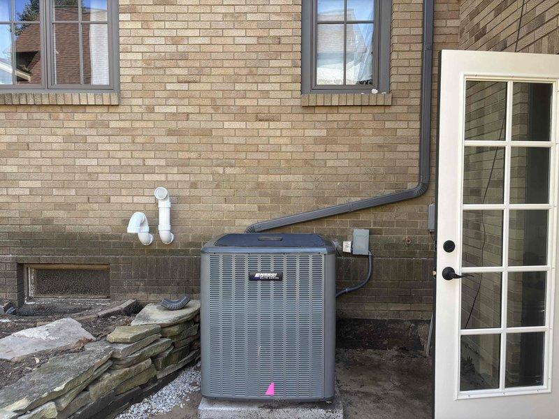 Returned to property to complete reinstallation of outdoor air conditioning condenser unit on existing concrete pad against exterior brick wall. Successfully repositioned and secured unit, reconnected refrigerant lines and electrical connections, verified proper drainage through condensate line, and performed system startup and operational testing to ensure proper function.