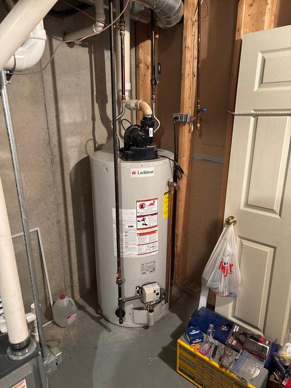 Provided estimate for tankless water heater replacement to replace existing Lochinvar tank-style water heater unit currently installed in basement utility area. Evaluated existing plumbing configuration including copper supply lines, pump assembly connections, and venting requirements for proper tankless unit installation.