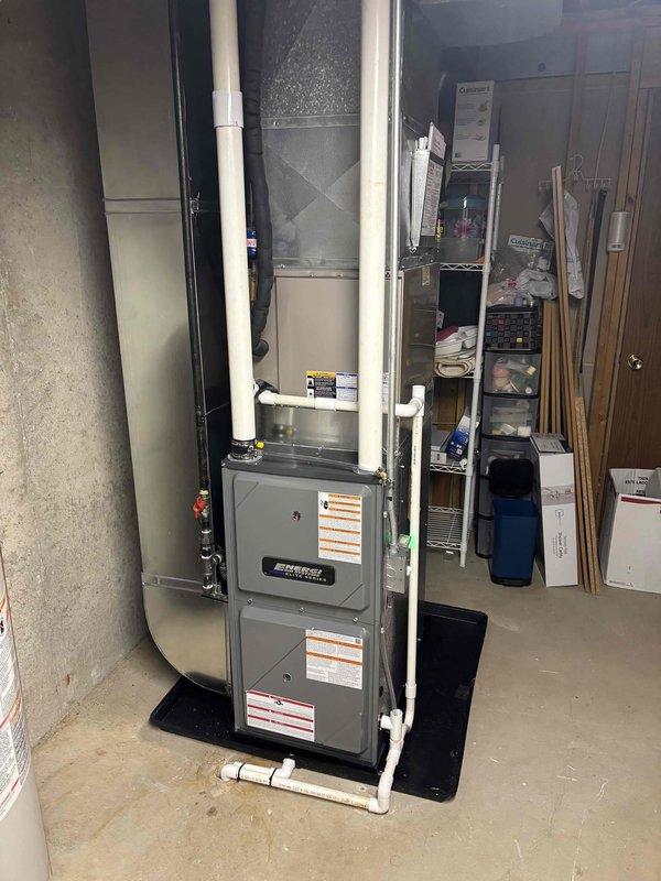 Completed full furnace installation in basement utility area. Installed new vertical furnace unit with proper ductwork connections, PVC condensate drainage piping, and venting system. All equipment positioned on concrete floor with adequate clearance for maintenance access, system tested and operational.