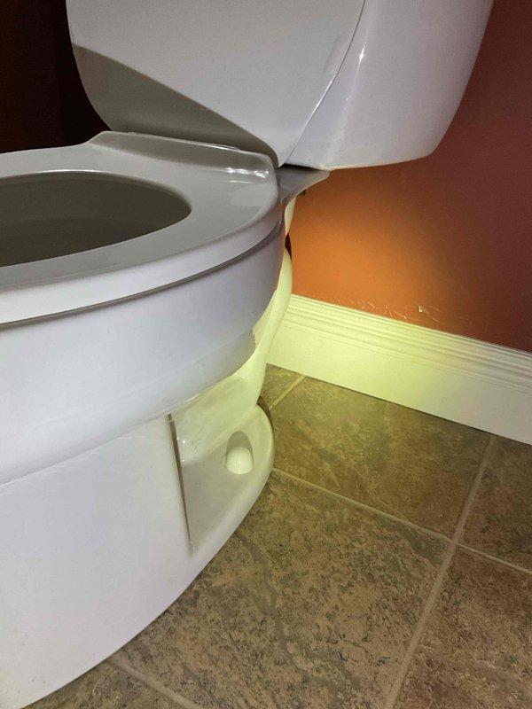 Responded to report of leaky toilet in 22-year-old residential property. Upon arrival, inspected standard two-piece white porcelain toilet with visible water supply line and shut-off valve. Identified source of leak and performed necessary repairs to resolve water seepage issue. Tested toilet operation following repair to confirm proper function and verify leak was fully eliminated. Documented conditions with photographs showing toilet installation, surrounding bathroom environment, and completed repair work.