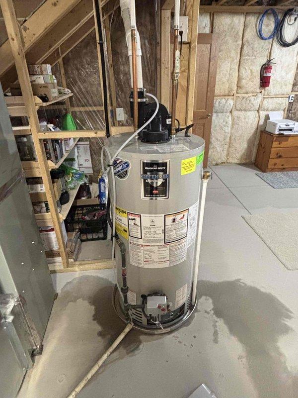 Responded to water heater leak complaint and performed inspection of 6-year-old residential unit. Upon arrival, confirmed water heater was leaking into drain pan, indicating potential tank failure or connection issue. Documented existing condition with photos showing unit placement in basement utility area and evidence of moisture accumulation. Assessed water heater for age-related deterioration and verified leak source at tank body, consistent with internal tank corrosion typical of units in this age range. Customer contacted for authorization to proceed with replacement recommendations.