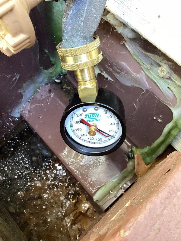 Responded to complaint of knocking noise in plumbing pipes throughout house when using hot or cold water, occurring after recent technician visit. Upon arrival, performed diagnostic assessment of plumbing system in 1997-built home, focusing on left side of structure where noise was primarily reported. Tested static water pressure at hose bib using calibrated pressure gauge to determine if excessive pressure was causing water hammer condition. Inspected Bradford White water heater installation, copper supply lines, and associated plumbing connections in mechanical room for loose pipes, inadequate securing, or missing water hammer arrestors. Verified proper pipe support and checked for thermal expansion issues that could contribute to knocking sounds. Documented system pressure readings and condition of plumbing infrastructure with photographic evidence. Provided findings and recommendations to address the water hammer condition in the residential plumbing system.