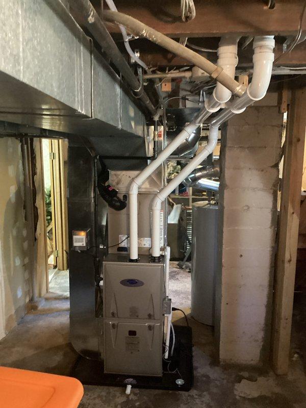 Completed full HVAC system installation in basement mechanical room, including new residential furnace unit and air conditioning system. Installed all required PVC ventilation piping, metal ductwork, and associated plumbing connections running to ceiling joists with proper support brackets and straps. System tested and verified operational upon completion.