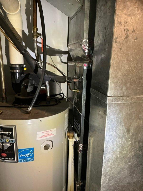Completed AC tune-up and estimate on a 10-year-old Goodman system located in basement utility area. Performed standard maintenance inspection of air handler and associated ductwork, documented equipment condition with photos showing HVAC unit alongside water heater in unfinished basement space. System operational at time of service completion.