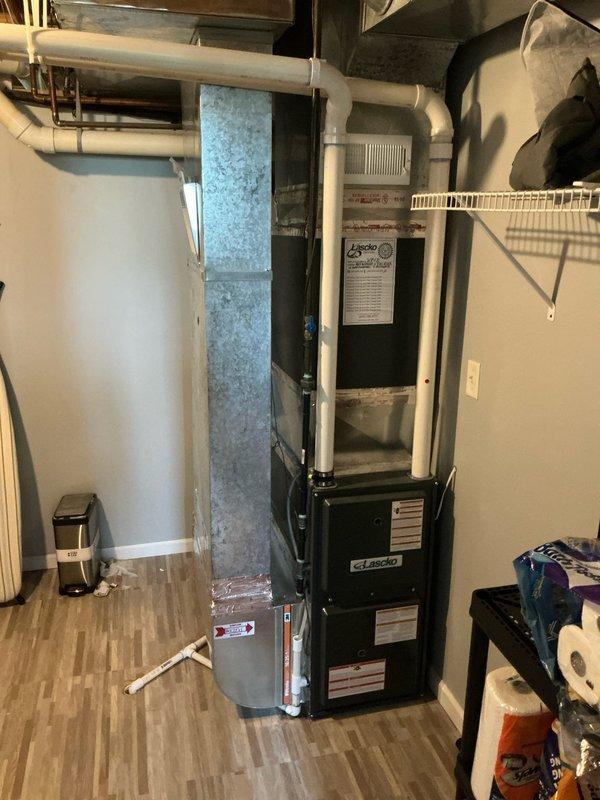 Completed AC tune-up and estimate on a 10-year-old Goodman system located in basement utility area. Performed standard maintenance inspection of air handler and associated ductwork, documented equipment condition with photos showing HVAC unit alongside water heater in unfinished basement space. System operational at time of service completion.