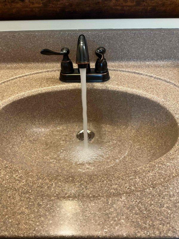 Responded to a leaking pop-up drain assembly at a bathroom sink faucet that had been dripping for approximately one month. Upon inspection of the 20-year-old fixture with dual-handle oil-rubbed bronze faucet and chrome pop-up drain, identified worn drain stopper seal as the source of the leak. Disassembled pop-up assembly, cleaned components, and replaced deteriorated gasket and stopper mechanism. Tested operation of pop-up drain and verified proper seal with no further leakage detected. Faucet handles and water flow functioning normally upon completion.