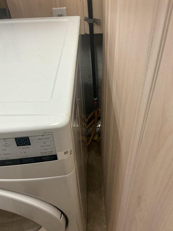 Completed gas line rework in residential laundry area, relocating and securing copper gas piping with proper safety marking behind washing machine installation. Accessed and modified overhead utility routing through ceiling infrastructure to ensure code-compliant clearances and safe appliance operation.