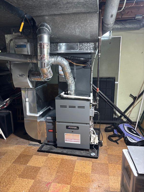 Completed full air conditioning system replacement in residential basement utility area. Installed new furnace unit on protective drainage pan with proper floor mounting, connected comprehensive metallic ductwork system including rigid and flexible sections with secure joints and transitions. Integrated air handler unit, established all necessary electrical connections, and verified proper routing of refrigerant lines and condensate drainage. All ductwork sealed at connection points, system tested for operational functionality, and installation completed per manufacturer specifications.