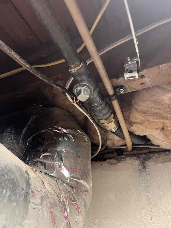 Conducted tankless water heater estimate at residential property. Inspected existing plumbing infrastructure in crawl space, documenting current water heater installation including copper supply lines, mechanical components, and structural mounting locations. Photographed existing piping configuration showing transitions between different pipe materials and assessed accessibility for potential tankless unit installation. Provided comprehensive estimate for tankless water heater replacement considering existing plumbing layout and necessary modifications.