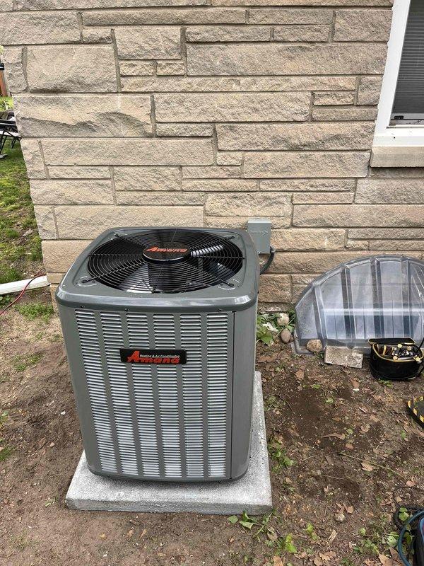 Completed full HVAC system replacement including indoor air handler unit installed in basement utility room and outdoor condensing unit positioned on concrete pad against exterior foundation wall. Both units properly connected with refrigerant lines, electrical service, and condensate drainage per manufacturer specifications. System tested and verified operational.