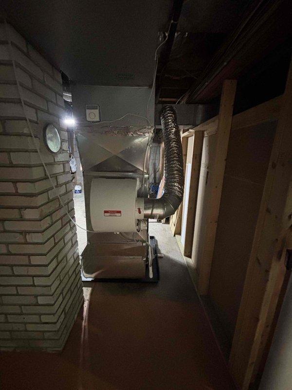 Completed full residential HVAC system installation in basement utility room, including new furnace and air conditioning unit. Installed furnace on elevated platform with proper clearances, connected flexible ductwork to existing distribution system, and integrated with metallic trunk lines running across ceiling joists. Configured thermostat controls, verified all electrical connections, tested system operation for proper heating and cooling function, and confirmed adequate airflow throughout ductwork. Installation met manufacturer specifications and local building codes.