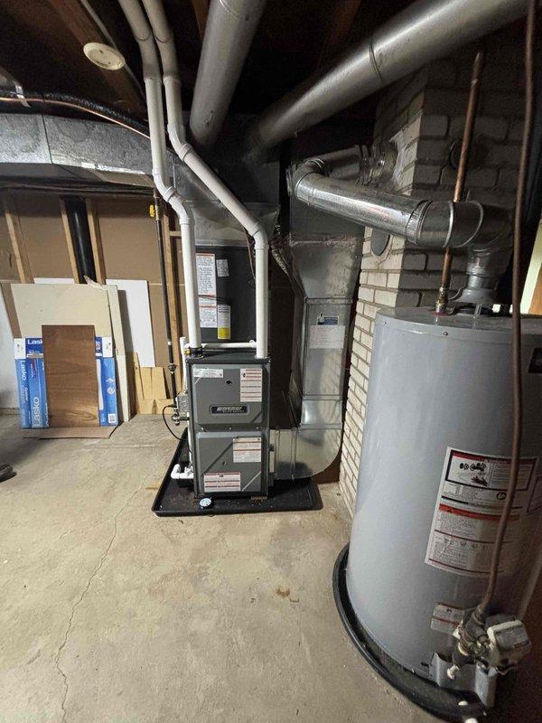 Completed full residential HVAC system installation in basement utility room, including new furnace and air conditioning unit. Installed furnace on elevated platform with proper clearances, connected flexible ductwork to existing distribution system, and integrated with metallic trunk lines running across ceiling joists. Configured thermostat controls, verified all electrical connections, tested system operation for proper heating and cooling function, and confirmed adequate airflow throughout ductwork. Installation met manufacturer specifications and local building codes.