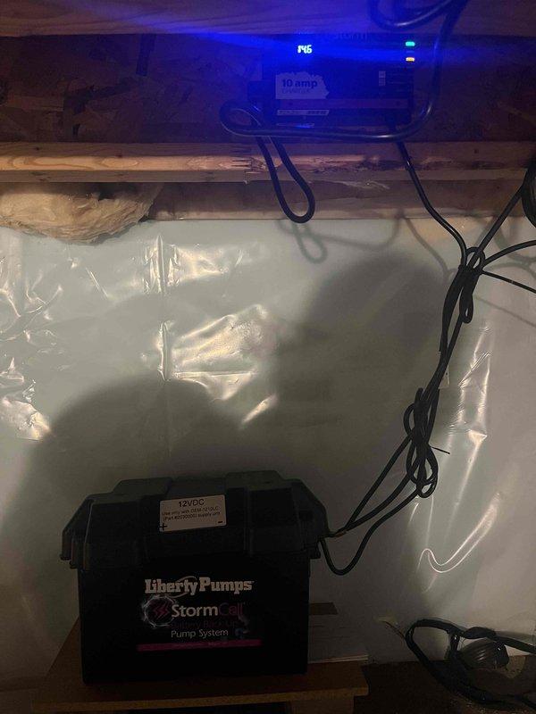 Completed installation of Liberty Pumps StormCell battery backup sump pump system in crawl space with 12VDC power supply and proper electrical connections. Removed existing toilet and installed new white porcelain toilet in bathroom with gray wood-look tile flooring, ensuring proper sealing, water supply connection, and operational testing upon completion.