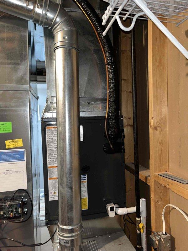 Completed full HVAC system installation including indoor air handler unit in basement utility area with new metallic ductwork runs and elbow connections. Installed outdoor condensing unit on concrete pad with proper gravel base, connected refrigerant lines and electrical disconnect box mounted to exterior wall. All components properly secured, labeled, and tested for operation per manufacturer specifications.