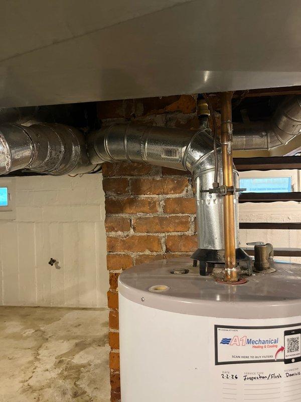 Responded to emergency call for water leakage behind residential water heater. Upon arrival, discovered pooling water at base of approximately 23-year-old water heater unit in basement utility area. Conducted thorough visual inspection of unit and surrounding plumbing infrastructure, including overhead copper supply lines, PEX connections, and associated piping. Documented existing conditions with photographs showing water heater installation, exposed plumbing system with multiple pipe materials (copper, PEX, flexible ductwork), and overall mechanical room configuration. Assessed age and condition of unit to determine source of leak and provided recommendations for necessary repairs or replacement given the advanced age of the equipment.