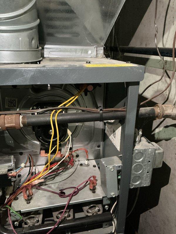 Completed rental inspection of HVAC system and water heater installation. Documented furnace interior components including blower motor assembly, electrical connections with wire nuts, copper refrigerant lines showing age-related oxidation, and ductwork configuration. Inspected water heater plumbing system with blue ball valve shutoff, noting corrosion on metal piping and threaded connections. Verified condensate overflow sensor placement on basement floor and photographed all mechanical equipment for rental property documentation.