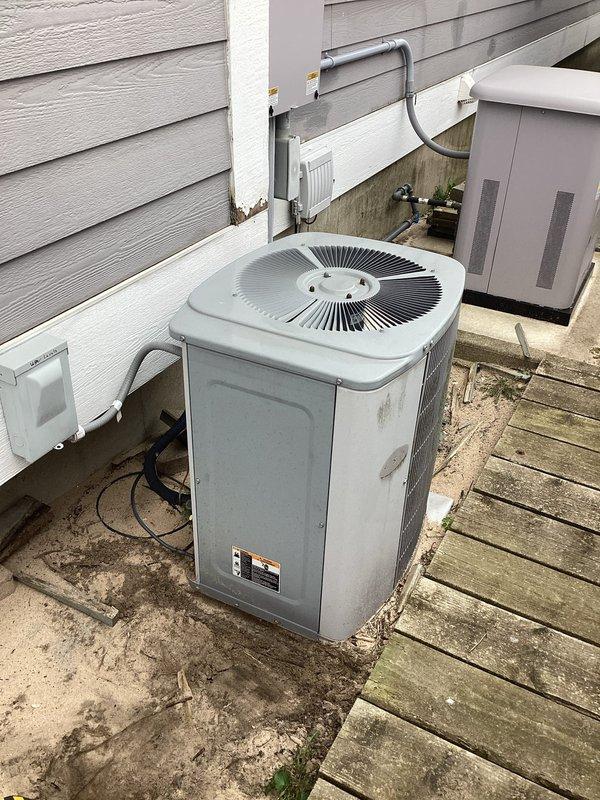Replaced defective gas valve on hydronic heating system serving multi-floor zone distribution manifold with green circulators labeled for third floor west zone. Completed AC repairs on outdoor condenser unit including cleaning weathered components and verifying proper operation of disconnect and electrical connections.