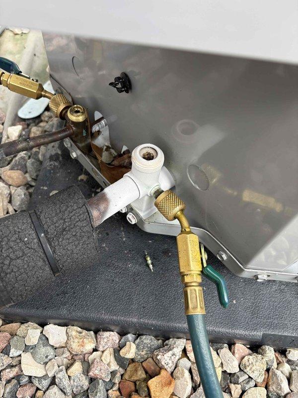 Responded to a return service call for a 4-year-old Carrier condo unit experiencing insufficient cooling capacity. Previously serviced the system one year ago for low refrigerant charge, at which time UV dye was added to the system for leak detection. Upon arrival, confirmed unit was operating but unable to reach setpoint temperature. Connected manifold gauges and digital testing equipment to service ports on outdoor unit to verify refrigerant pressures and system performance. Found refrigerant charge low again, indicating a leak in the system that requires further diagnosis and repair.