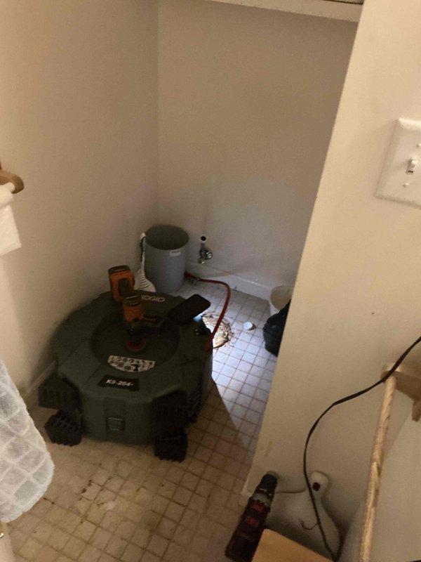 Responded to recurring drain blockage in residential bathroom that had previously been cleared. Upon arrival, set up wet/dry vacuum equipment to address the stoppage. Performed drain cleaning procedures on toilet drain line using mechanical methods. Blockage was successfully cleared and drainage restored to normal flow. Verified proper operation of fixture after completion. Equipment was staged in bathroom work area during service. Issue appears to be related to recurring buildup in the line requiring periodic maintenance intervention.