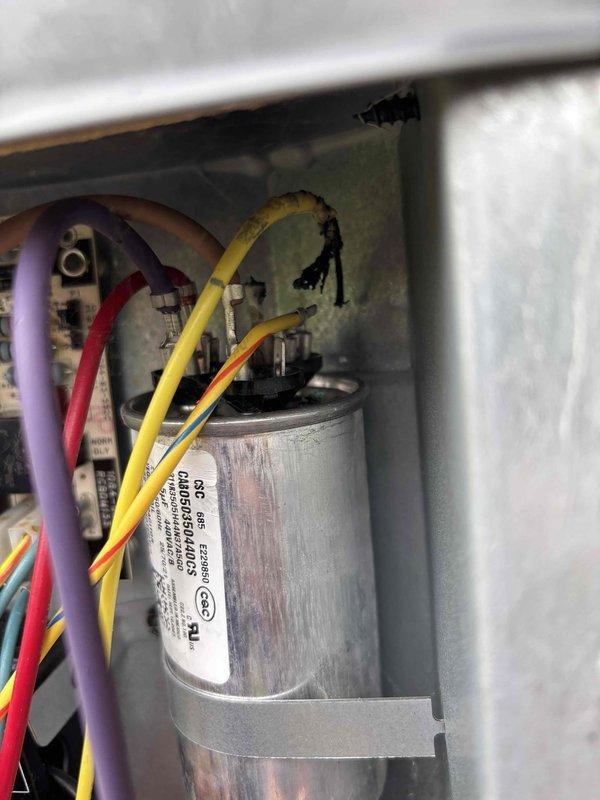 Responded to no-heat call on one-year-old heat pump system. Upon inspection, discovered failed dual run capacitor with severe heat damage and charring at terminal connections. Removed defective capacitor and installed new replacement unit, reconnected all wiring to proper terminals, and verified system operation with successful heat pump startup and normal heating cycle.