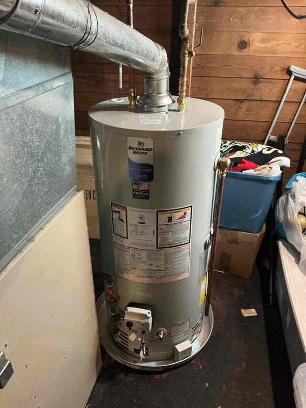 Successfully completed installation of a 40-gallon natural gas Bradford White water heater in residential utility area. Installed unit with proper venting through galvanized metal ductwork, connected water supply lines with shut-off valves, and ensured all manufacturer specifications and safety requirements were met per code.