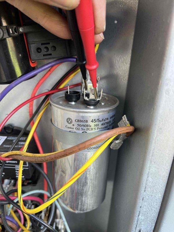 Completed annual cooling maintenance on 12-year-old EnergiAir system with 2020 condenser model. Performed comprehensive tune-up including electrical testing of dual-run capacitor (CRB65B, 45/5 MFD, 370V) using multimeter to verify proper microfarad readings and ensure reliable compressor and condenser fan motor operation. Inspected exterior condensing unit mounted on building with proper clearances, verified all electrical connections secure, and documented equipment condition through diagnostic photography.