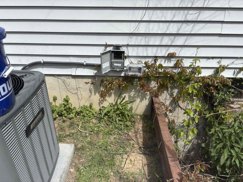 Completed full residential HVAC system installation including new furnace and air conditioning unit. Furnace installed in unfinished basement utility area with proper venting via white PVC piping, connected to existing ductwork system, and mounted on code-compliant base platform. Exterior AC condenser unit positioned on building exterior near electrical meter with appropriate clearances maintained. All refrigerant lines, electrical connections, and condensate drainage properly installed and tested for system functionality.