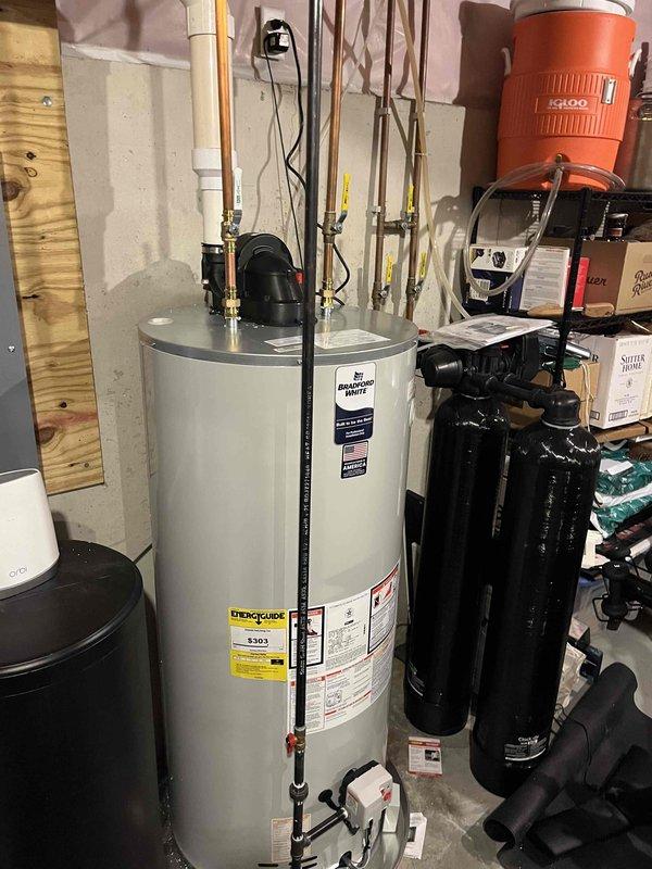 Completed full installation of new furnace and air conditioning system in residential basement utility area. All equipment properly positioned, connected to existing ductwork, and integrated with plumbing infrastructure including water heater, water softener, and pressure tank systems. System tested and verified operational with all electrical connections, refrigerant lines, and condensate drainage functioning per manufacturer specifications.