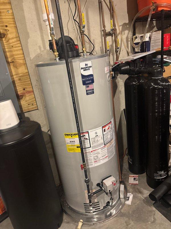Completed full installation of new furnace and air conditioning system in residential basement utility area. All equipment properly positioned, connected to existing ductwork, and integrated with plumbing infrastructure including water heater, water softener, and pressure tank systems. System tested and verified operational with all electrical connections, refrigerant lines, and condensate drainage functioning per manufacturer specifications.