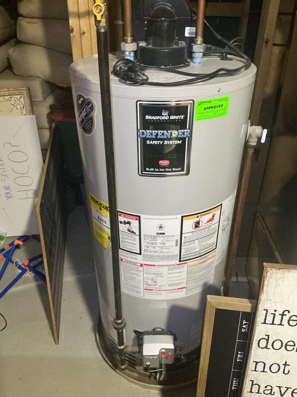 Responded to service call for Bradford White Defender Safety System water heater not reaching temperature setpoint. Performed diagnostic inspection of approximately 6-year-old unit installed in basement utility area. Verified gas supply valve operation, inspected all copper piping connections and shut-off valves at top of unit for proper configuration. Examined thermocouple and pilot assembly through access panel. Checked temperature pressure relief valve and all visible plumbing connections including PEX hot and cold water supply lines for leaks or restrictions. Documented unit condition with photographs showing proper venting, gas line connections, and overall installation setup. Unit specifications and safety labels verified to be intact and legible.