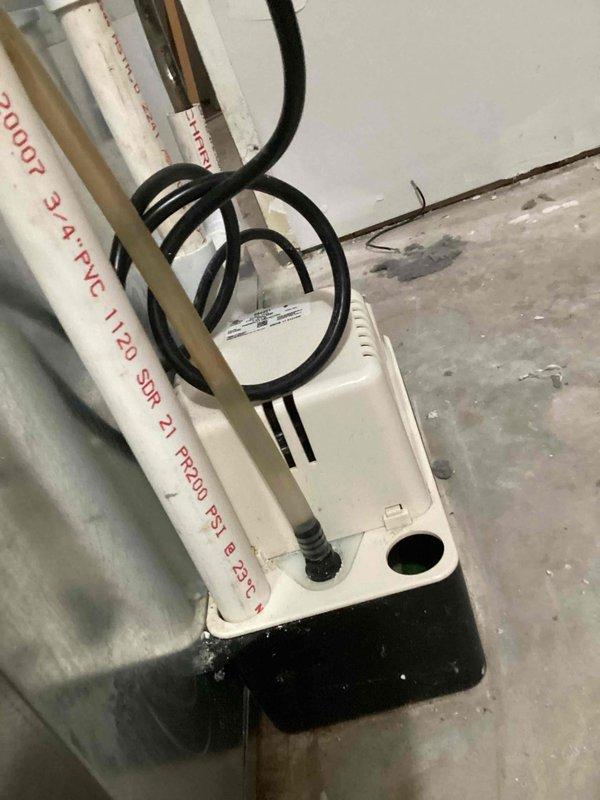 Completed annual cooling maintenance on 9-year-old air conditioning system. Performed comprehensive tune-up including inspection of condensate drain line and safety float switch assembly. Documented condensate management components showing proper installation of 3/4" PVC drain line with appropriate pressure rating and functional float switch with connected wiring. All condensate system components operating correctly with no blockages or drainage issues observed. System checked and confirmed ready for cooling season operation.