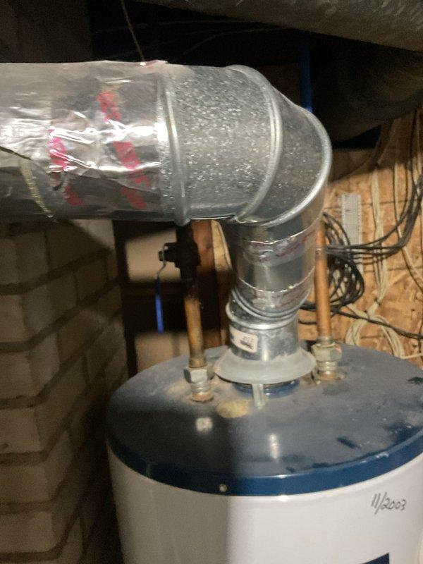 Conducted on-site evaluation for replacement of existing 16-year-old 40-gallon gas-fired water heater located in unfinished basement area with chimney venting configuration. Inspected current installation including gas supply lines, water connections with blue-handled shut-off valves, copper piping, electrical wiring, venting ductwork with condensation present, and concrete floor mounting location. Documented existing equipment condition, clearances, and accessibility for replacement purposes. Assessed chimney venting system compatibility and structural framing in utility space to provide comprehensive estimate for new water heater installation with proper venting, gas connections, and code-compliant setup.