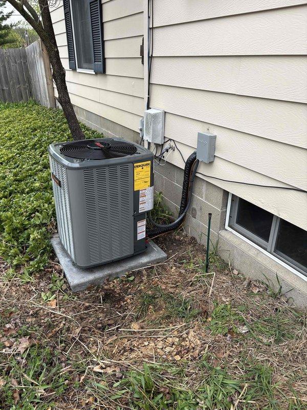 Completed full air conditioning system installation including outdoor condenser unit positioned on concrete pad with proper clearances from structure. Installed refrigerant lines, electrical disconnect box, and flexible conduit routing from unit to building exterior. System charged with refrigerant to manufacturer specifications, documented refrigerant levels at 55/55 on service label, and verified all electrical connections secure and operational.