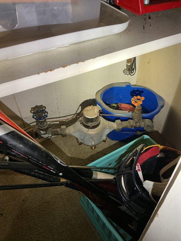 Conducted comprehensive plumbing assessment of 90-year-old residential property with aging copper pipe infrastructure showing significant corrosion and patina buildup. Documented existing conditions of utility area plumbing system, including corroded gate valves, deteriorating copper supply lines, and outdated pipe mounting hardware requiring replacement. Photographed under-sink plumbing configurations and laundry area utility connections to provide detailed estimate for complete pipe replacement project.
