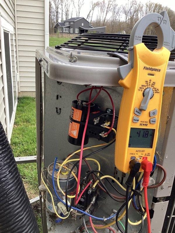 Completed annual cooling maintenance and tune-up on residential HVAC system. Performed comprehensive inspection of outdoor condensing unit, including electrical component testing with digital multimeter showing 4.18 reading on capacitor. Verified proper operation of contactor, capacitor, and all electrical connections. Inspected indoor equipment and condensate drainage system with PVC piping configuration. System operating within normal parameters following tune-up procedures.
