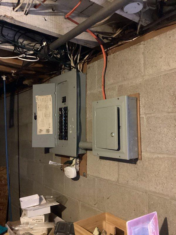 Responded to client request for electrical panel upgrade to accommodate kiln installation in garage. Upon arrival, assessed existing electrical infrastructure including current panel configuration and utility meter setup. Documented existing three-panel system mounted on basement concrete block wall, consisting of main breaker box and subpanels with overhead conduit routing. Evaluated exterior meter installation (Elster Type SUO, CL200, 240V, 3W, 60Hz) to determine service capacity for required upgrade. Provided assessment and recommendations for panel upgrade necessary to support additional high-amperage kiln circuit requirements, ensuring adequate electrical capacity and code compliance for the planned garage installation.