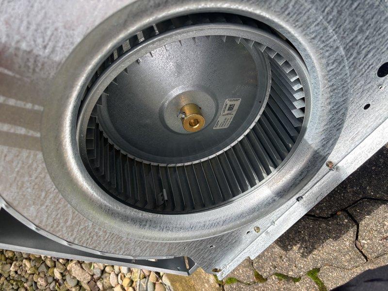 Completed annual cooling maintenance on 6-year-old EnergiAir system (Model WT 10-2029, condenser manufactured 2022). Performed comprehensive tune-up including inspection of blower wheel assembly, which showed normal wear and minor dust accumulation consistent with outdoor installation. Verified proper operation of squirrel cage fan and motor shaft mounting, documented equipment condition with photos showing functional blower assembly within housing unit.