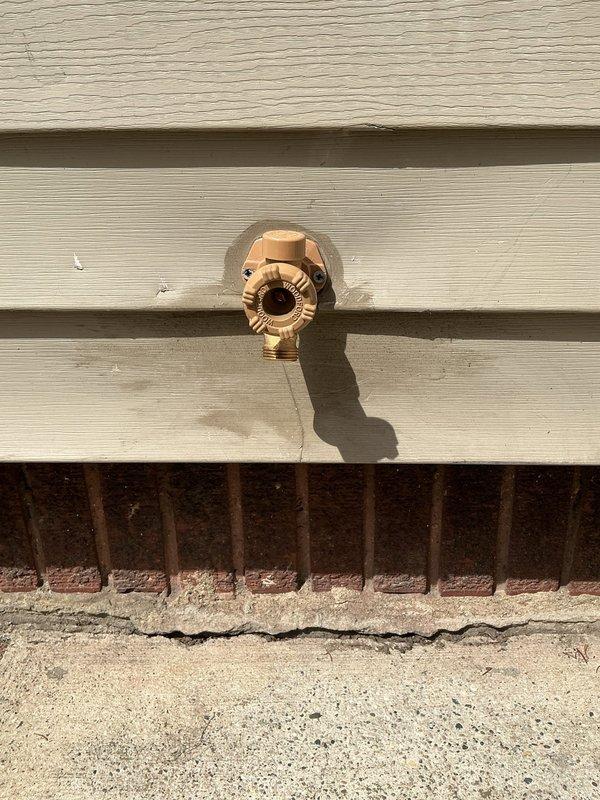 Completed replacement of exterior hose bib on building's outer wall. Removed old weathered fixture and installed new brass outdoor faucet with proper mounting to ensure secure attachment to siding. Accessed interior crawl space to verify supply line connections and confirm proper shut-off valve operation. All connections tested and confirmed leak-free with full water pressure restored to exterior spigot.