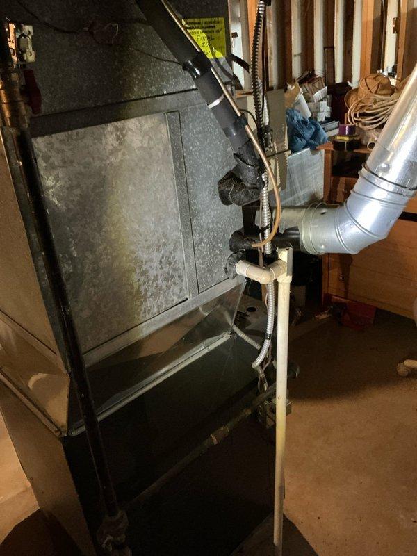 Conducted comprehensive furnace replacement estimate for residential property with existing aging HVAC system in basement utility space. Evaluated current furnace unit showing signs of wear and documented complete system layout including interconnected dehumidifier, air handler components, ductwork configuration, and PVC condensate drainage. Photographed equipment specifications, spatial constraints, and existing installation to provide accurate replacement recommendations and system upgrade options.