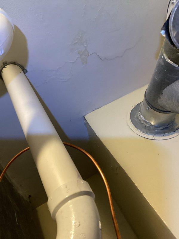 Completed annual cooling maintenance on 5-year-old Amana system installed in 2023. Performed standard tune-up procedures including inspection of refrigerant lines, electrical connections, and mechanical components. Documented existing water damage on ceiling near drainage lines and noted copper tubing routing in attic space, as well as gas line connections and water heater assembly in mechanical area for reference.