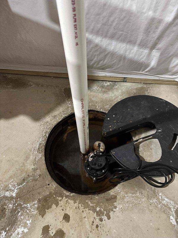 Conducted site assessment and provided project estimate for potential sump pump replacement in eleven-year-old residential property. Inspected existing submersible sump pump system with PVC discharge piping in basement area, noting water staining on concrete floor and functional pump assembly within basin. Documented current system condition and exterior discharge configuration for quote preparation, with no immediate operational issues identified at time of inspection.