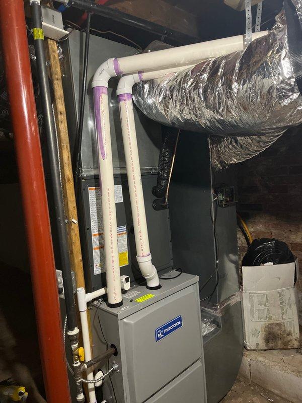 Completed add-on air conditioning installation to existing Armstrong furnace system. Installed outdoor condensing unit on concrete pad with proper gravel base and drainage, connected refrigerant lines through exterior wall, and integrated evaporator coil with existing forced air system. Installed condensate pump, PVC drainage piping, electrical disconnect, and all associated ductwork to provide complete cooling capacity to the home.