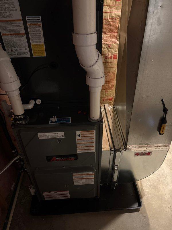 Completed full HVAC system installation in residential basement utility room, including new furnace and air handler units. Installed both units on concrete pad with proper spacing and framing, configured white PVC venting system with multiple joints and elbows for furnace exhaust and intake, and integrated all necessary piping connections including copper lines with shutoff valves. Routed flexible ductwork, completed electrical connections at junction box, and ensured proper insulation placement around equipment. All manufacturer specifications, safety labels, and regulatory information plates properly affixed to equipment. System tested and verified operational.