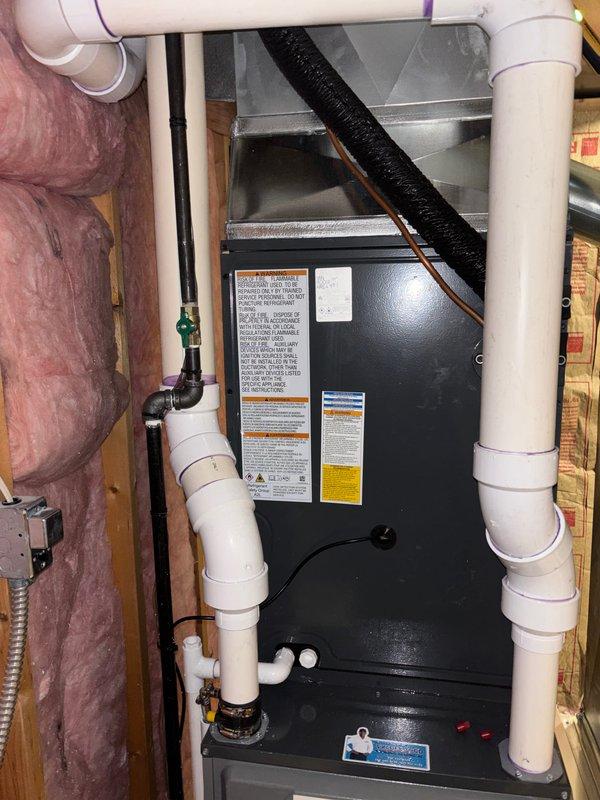 Completed full HVAC system installation in residential basement utility room, including new furnace and air handler units. Installed both units on concrete pad with proper spacing and framing, configured white PVC venting system with multiple joints and elbows for furnace exhaust and intake, and integrated all necessary piping connections including copper lines with shutoff valves. Routed flexible ductwork, completed electrical connections at junction box, and ensured proper insulation placement around equipment. All manufacturer specifications, safety labels, and regulatory information plates properly affixed to equipment. System tested and verified operational.