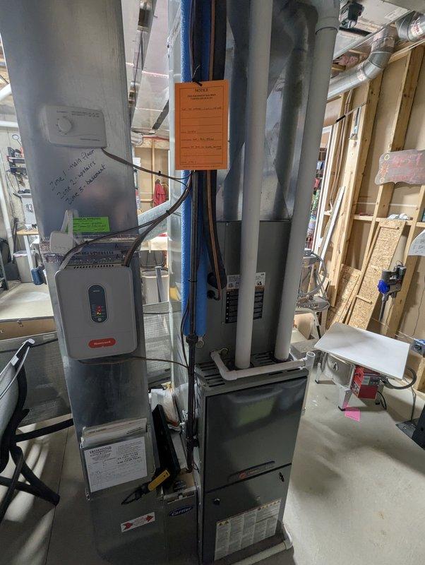 Completed annual cooling maintenance on 9-year-old Trane system with condenser manufactured in 2020. Performed comprehensive tune-up including inspection of indoor air handler, ductwork, and associated HVAC components. Documented existing equipment condition with photographs showing furnace cabinet, vertical duct runs with insulation, and mechanical room layout for service records.