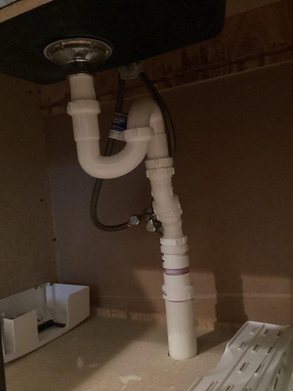 Responded to odor complaint in basement bathroom and sump pump room. Upon inspection, discovered corroded and stained sump pump basin with significant rust buildup around the discharge opening, indicating potential standing water and bacterial growth contributing to foul odors. Examined bathroom sink drain assembly and confirmed P-trap was properly installed and maintaining water seal. Documented conditions with photographs showing extent of corrosion in sump system and verified proper drainage configuration under sink to rule out dry trap as odor source.
